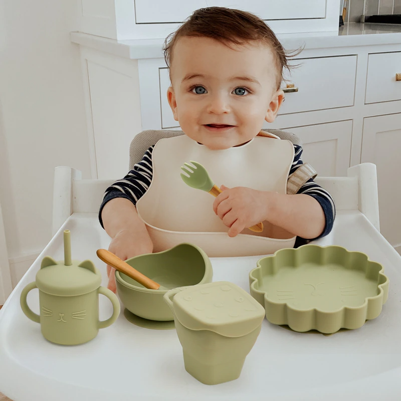 https://lovebubblestore.com/cdn/shop/products/13-descript-bpa-free-baby-silicone-plate-snack-cup-set-non-slip-kid-suction-plate-wooden-handle-silicone-spoon-bibs-baby-feeding-tableware.png?v=1668481382&width=1946